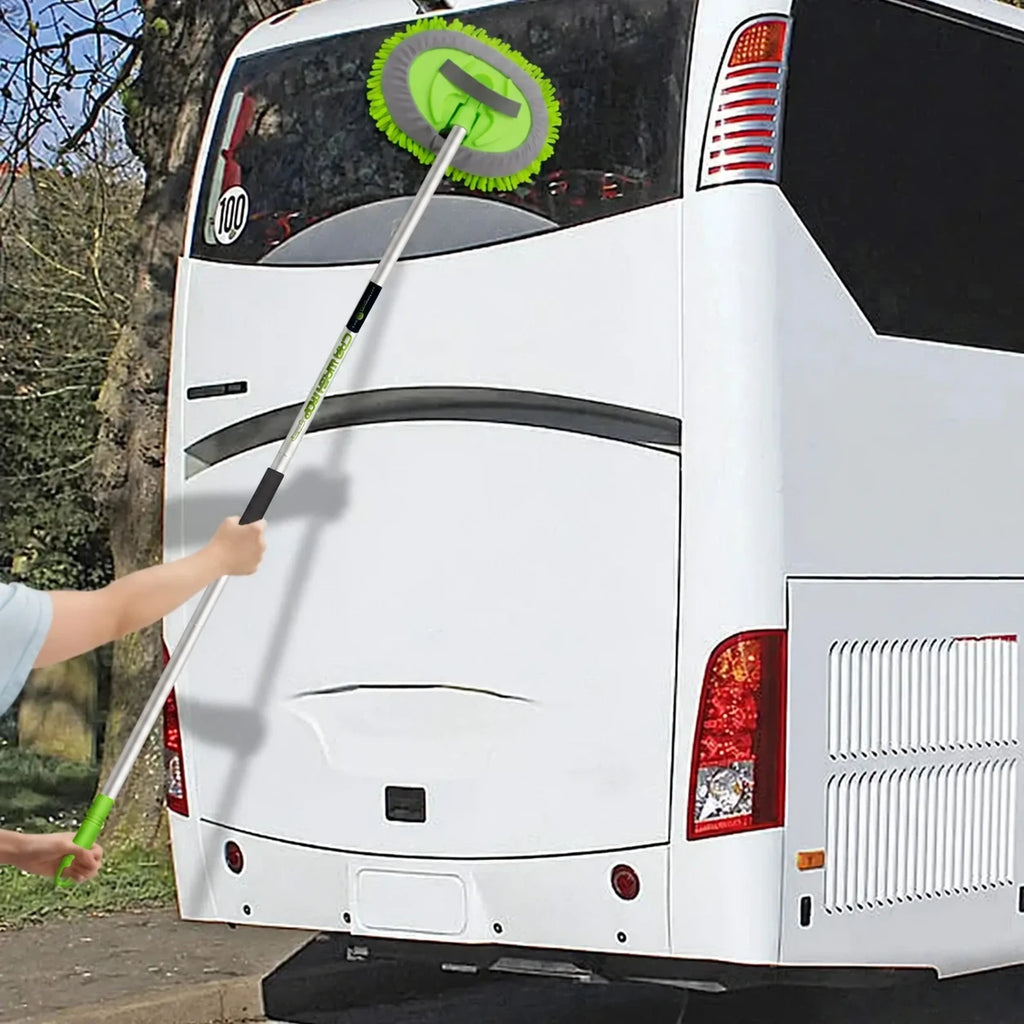 Persona usando el cepillo verde de mango largo para lavar la ventana trasera de un autobús