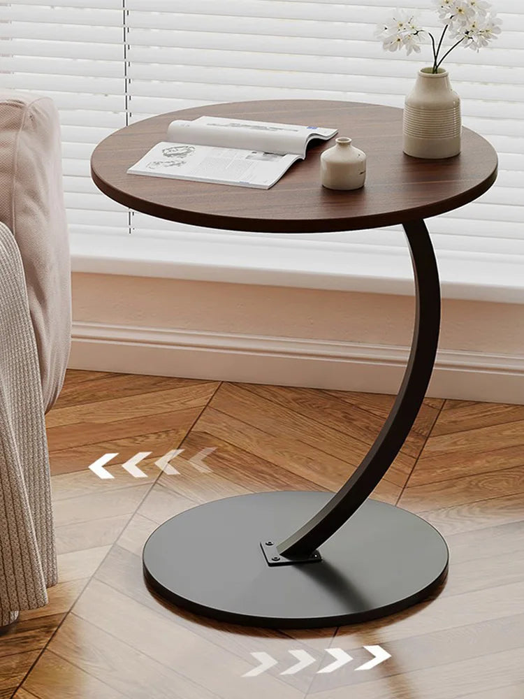 Mesa auxiliar de cubierta café y base curva negra junto a una ventana