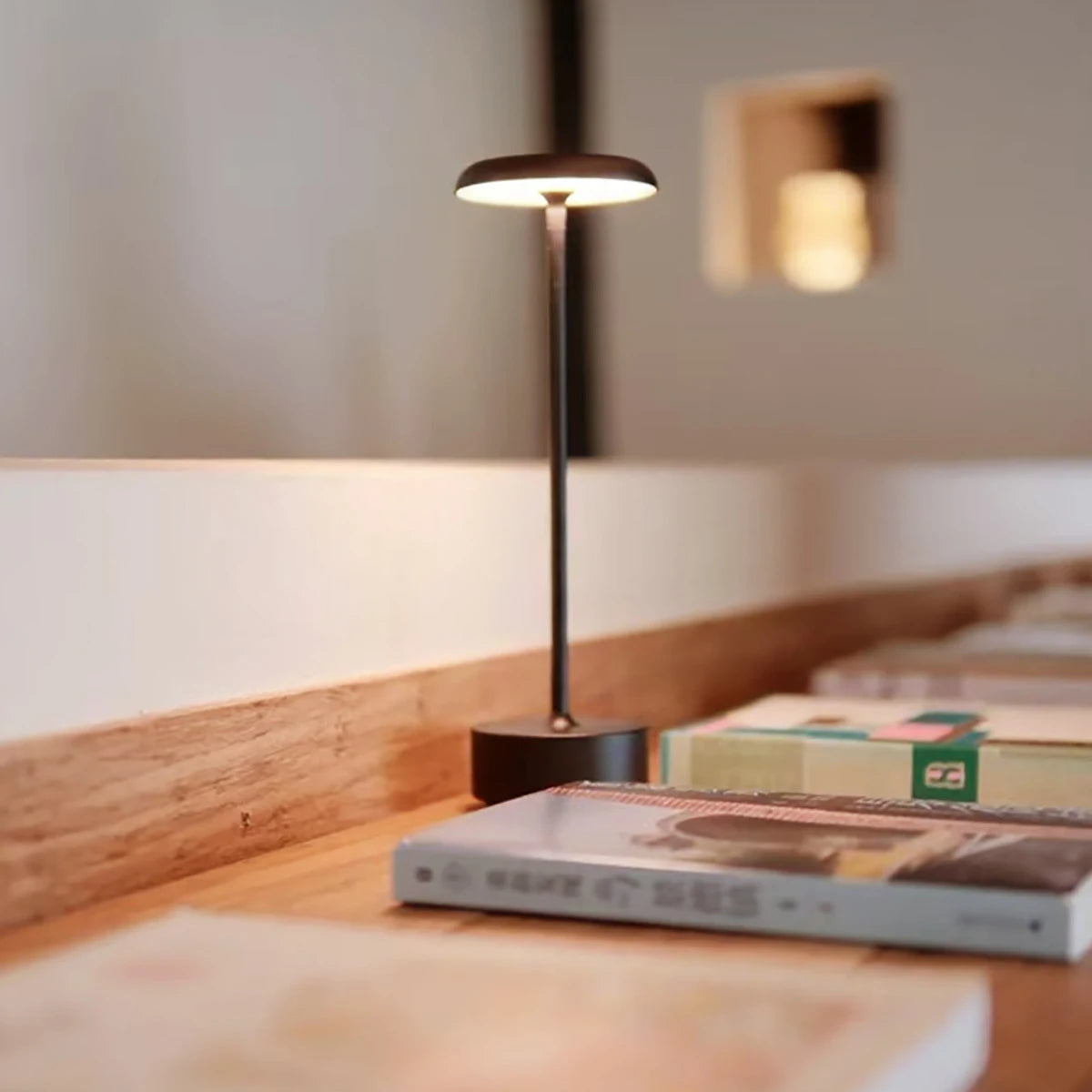 Lámpara de mesa encendida junto a libros.