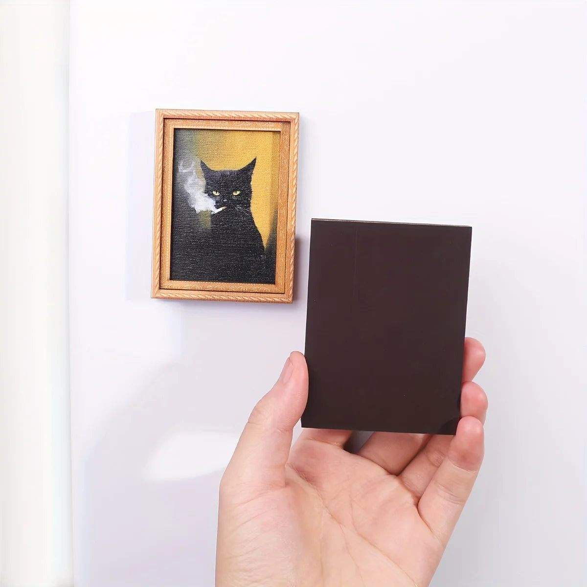 Imán con retrato de gato negro y vista de su parte posterior magnética.