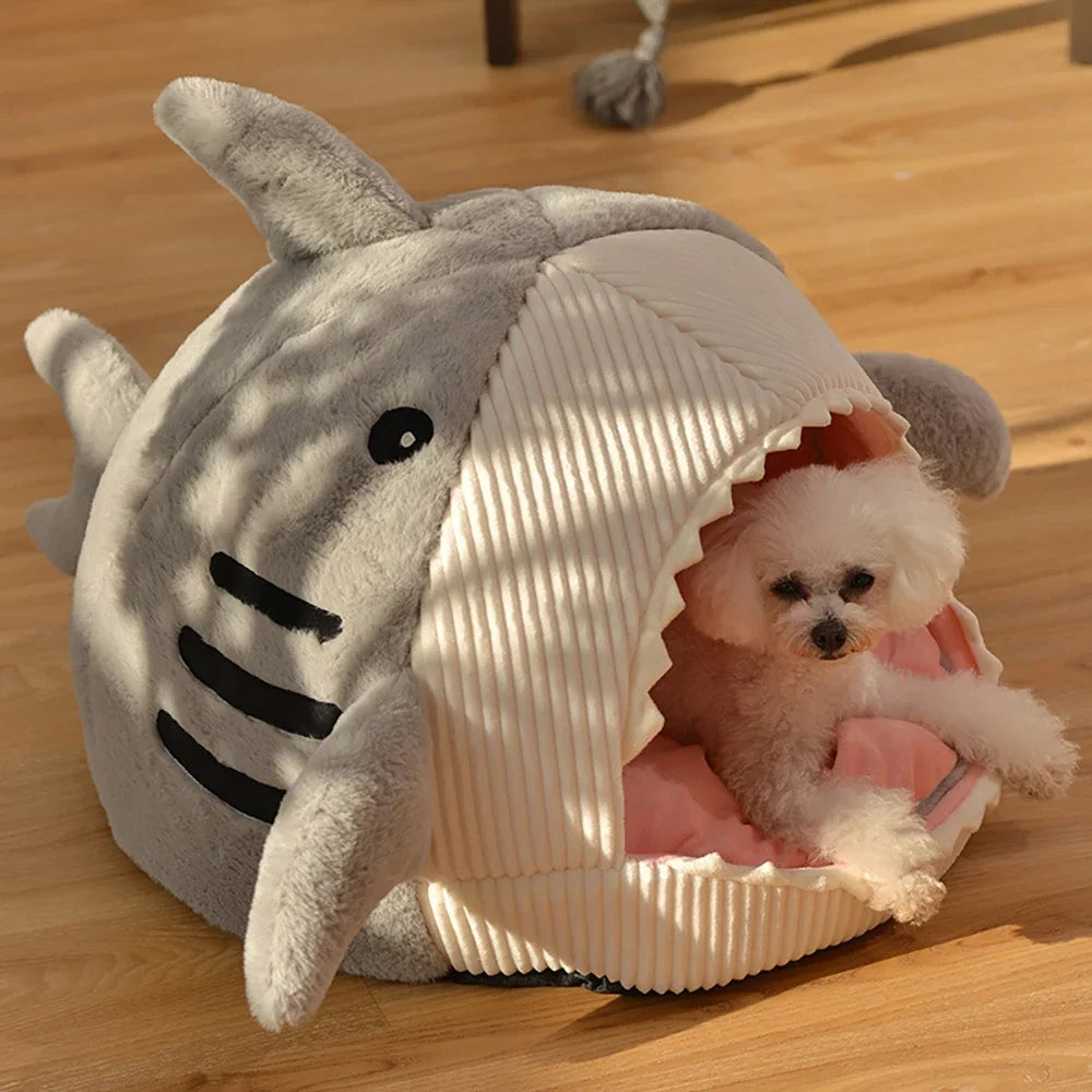Cama gris en forma de tiburón con una mascota pequeña en el interior