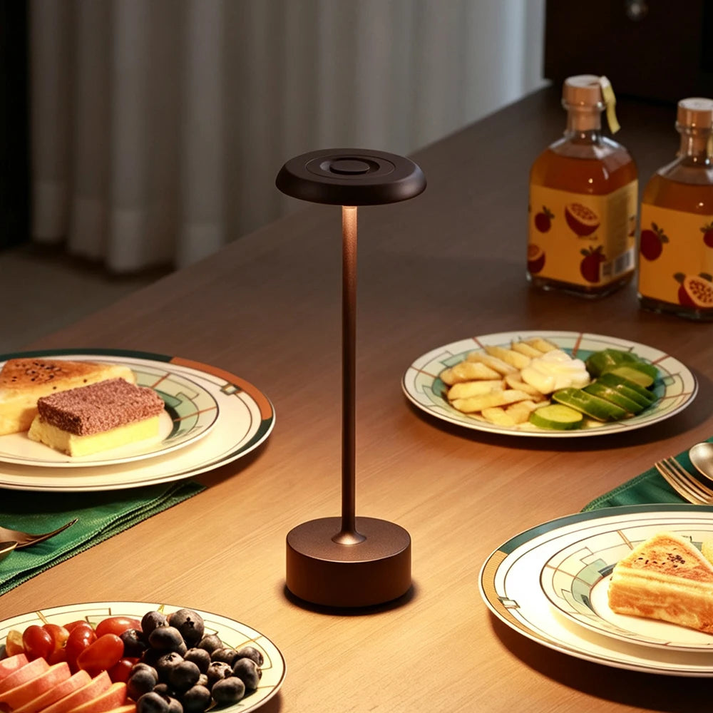 Lámpara de mesa en tono café sobre una mesa servida.