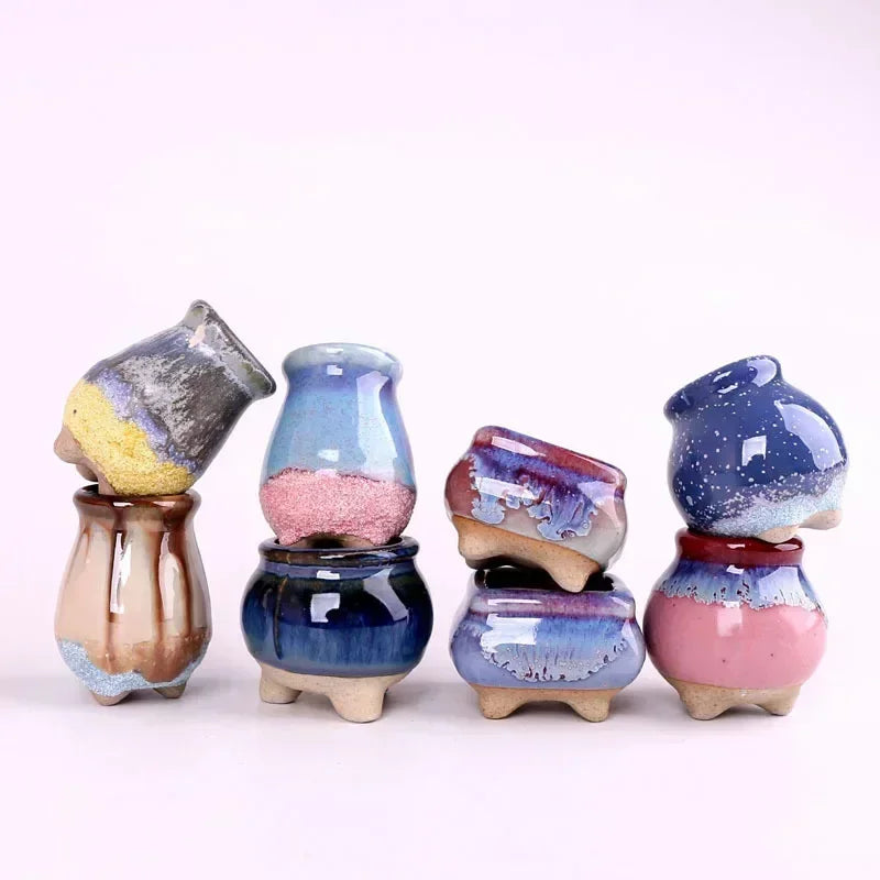 Surtido de macetas pequeñas de cerámica esmaltada en diferentes formas y colores.
