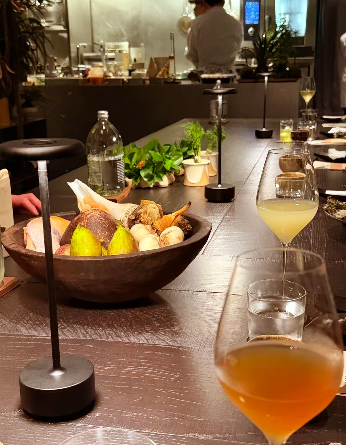 Lámpara negra encendida sobre una mesa de restaurante.