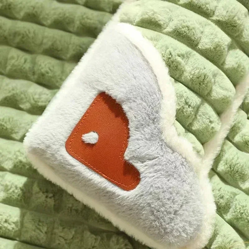 Detalle del apoyo lateral afelpado de la cama verde, con motivo de corazón.